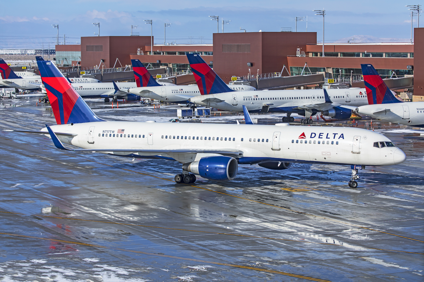 Delta Air Lines aircraft at the gate, with travelers checking delta flight status