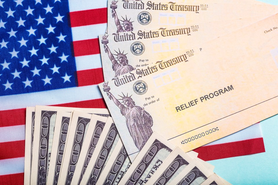 A stack of government stimulus checks and IRS forms related to stimulus check 2025