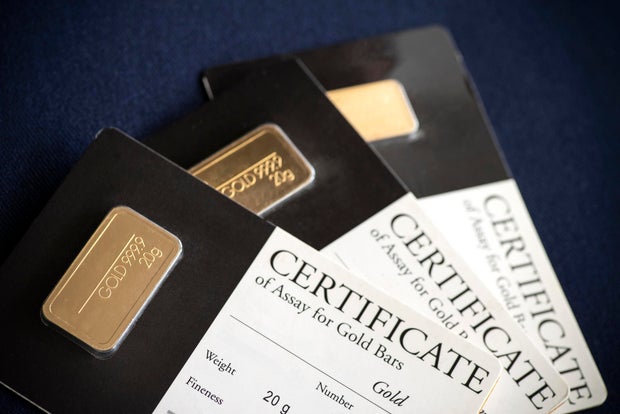 Gold bars and coins representing the price of gold today