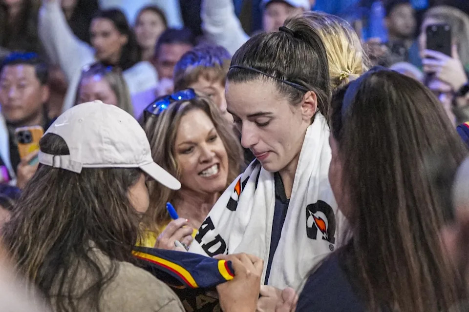 Caitlin Clark dribbling on court during a WNBA game, symbolizing her financial success